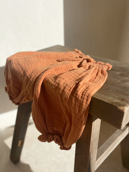 Organic cotton muslin pants for toddlers in terracotta

